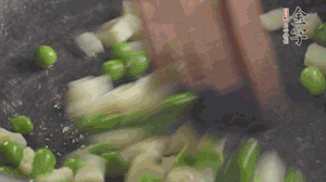 鍋中油7成熱時(shí)，入青豆、筍丁翻炒，然后加糯米飯加鹽均勻翻炒。