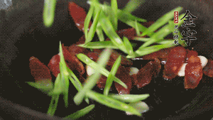 先后下香腸片、四季豆絲均勻翻炒，加適量清水燜煮一下。