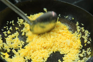 大火加熱炒鍋，再入油，燒到四至五成熱時(shí)倒入雞蛋液，在未凝結(jié)之前，加米飯煸炒，不停翻炒并用鍋鏟將成塊的米飯碾開(kāi)、撥散。