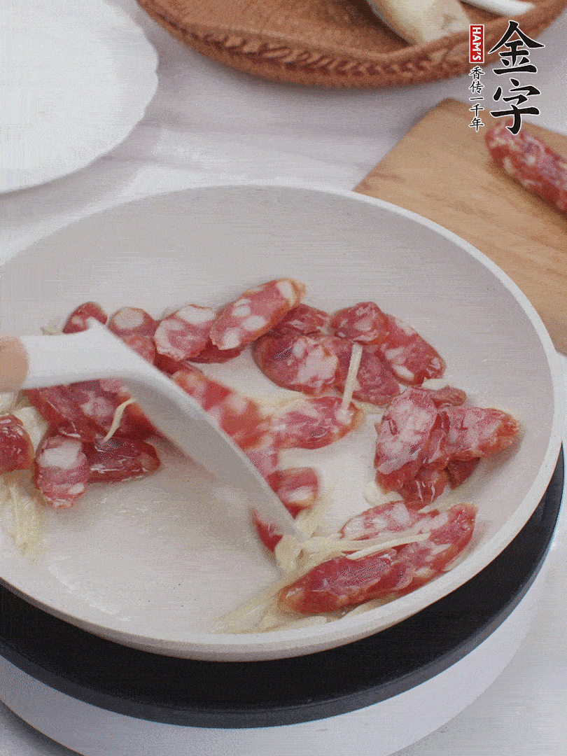 油溫3成熱時，下姜絲、蒜片、香腸炒出油脂。