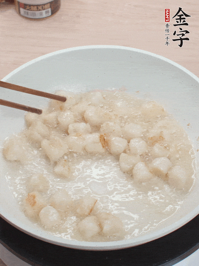 油溫4成熱，鮮貝蘸干淀粉下鍋煎，一面微黃后翻面。