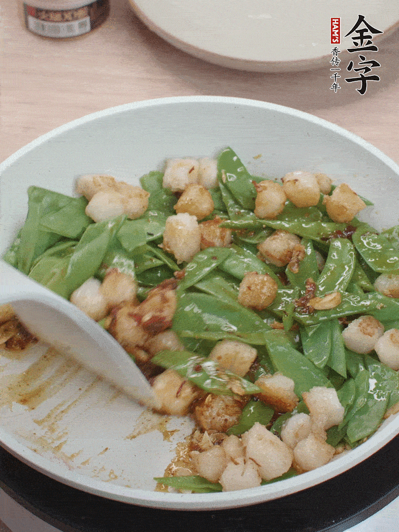 下甜豆莢、鮮貝輕輕翻炒均勻。