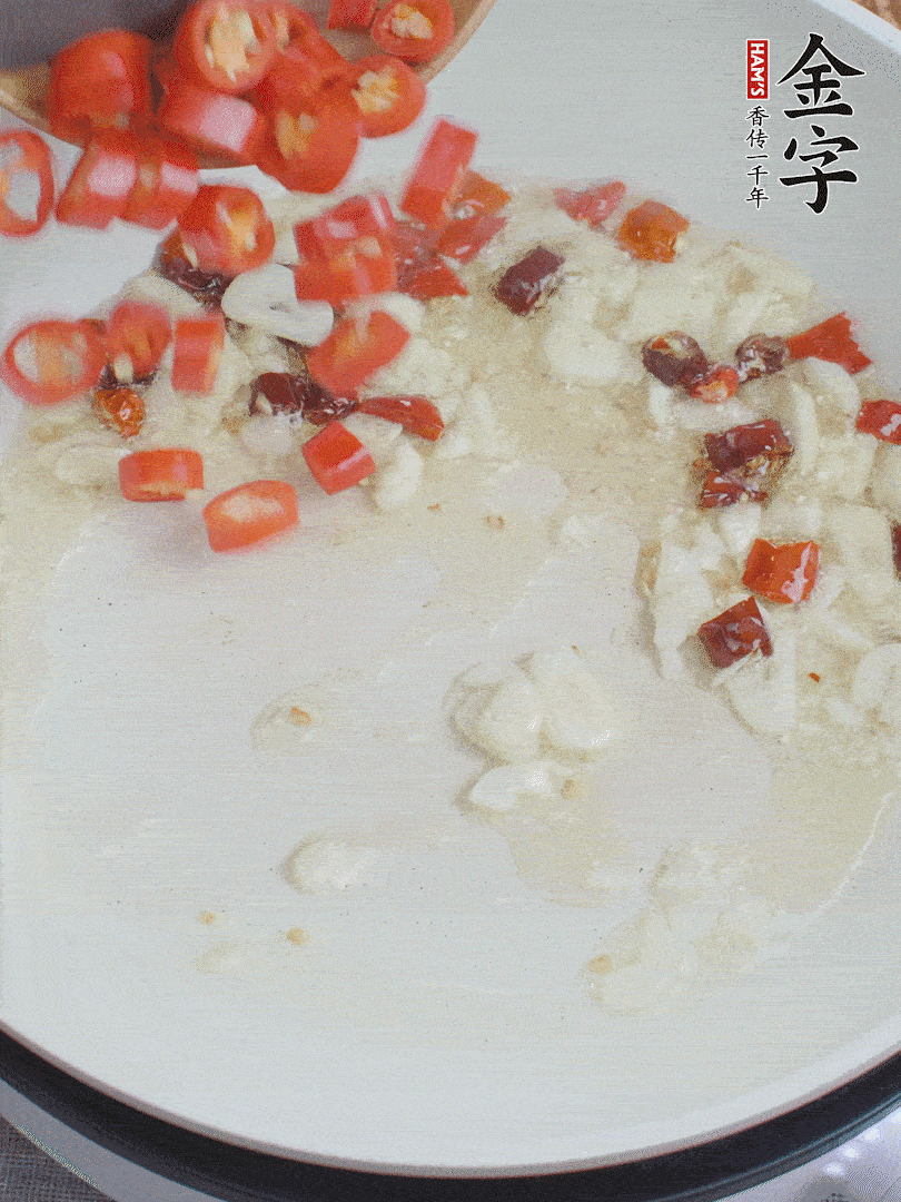 油6成熱，下蒜末、干紅辣椒煸炒，出香味后再放美人椒、香腸。