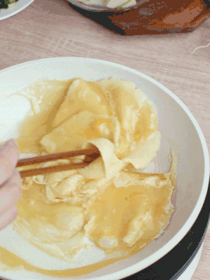 油6成熱時(shí)，下雞蛋液，邊緣凝固時(shí)翻拌成塊狀。