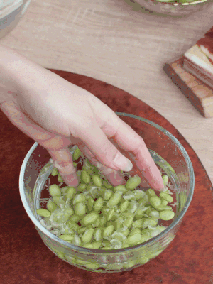 青豆剝殼，搓去外衣。