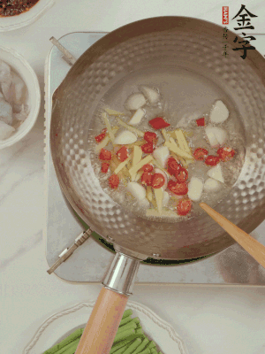 油7成熱時，下大蒜粒、姜絲、小米辣煸香。