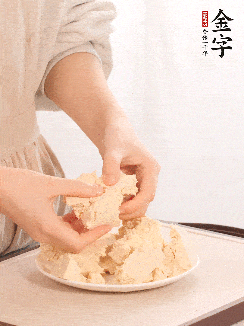 老豆腐用手掰成塊。