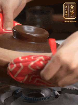 中火調(diào)成小火，鋪上香腸蓋蓋燜5分鐘。不斷轉動瓦煲，讓側壁的飯形成飯焦