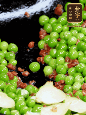 鍋內(nèi)少許油，下火腿煸香，再下甜豆米、百合翻炒，少許鹽、一點(diǎn)水煮到收干