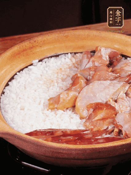 煮到椰子水微微收干轉(zhuǎn)小火，快速均勻鋪上雞肉、金字香腸